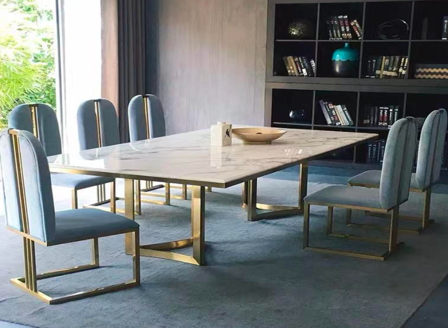 Marble dining table with brass details against a contemporary wall